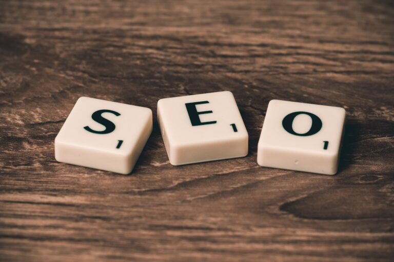 Three White-and-black Scrabble Tiles on Brown Wooden Surface Spelling SEO- for how to make money flipping websites